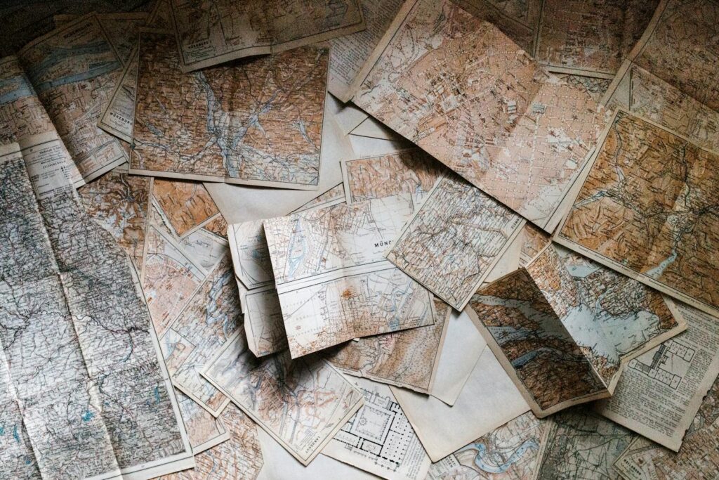 A collection of vintage maps scattered for exploring world journeys and discoveries.